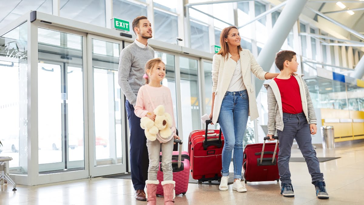 Family at the airport with luggage, ready for their family-friendly holiday.